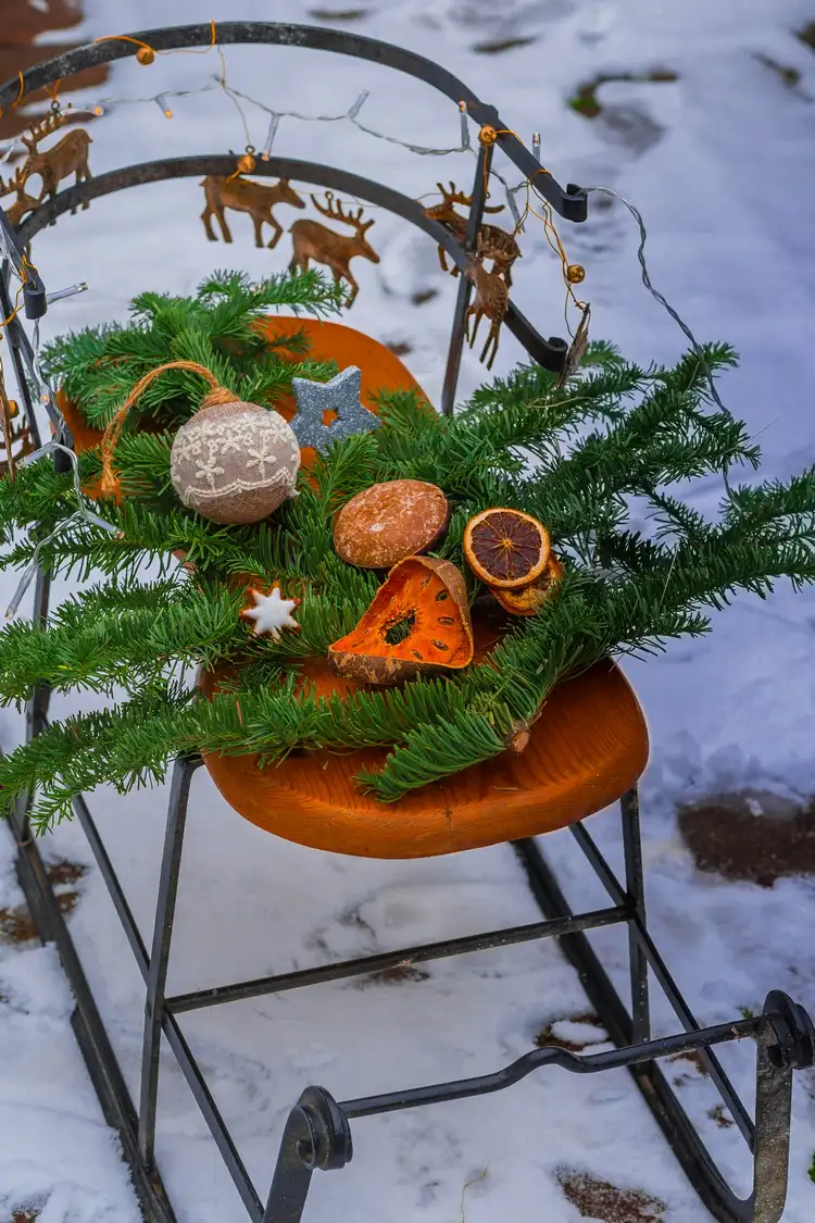 metal sleigh with fir greenery, dried fruits and reindeer garland