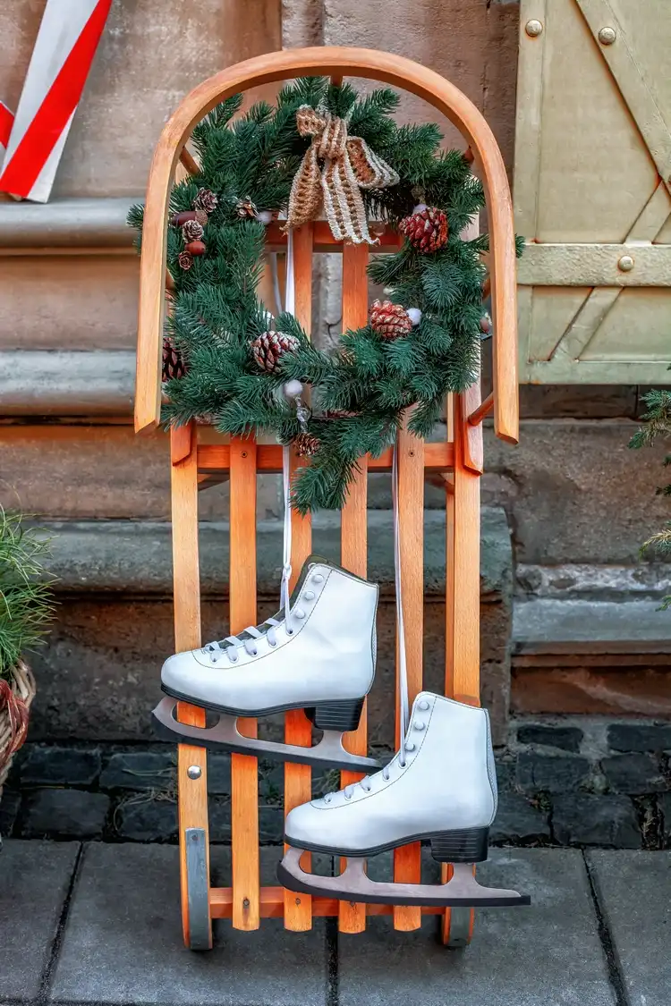 Beautiful winter decoration with wooden sleigh, winter wreath and ice skates