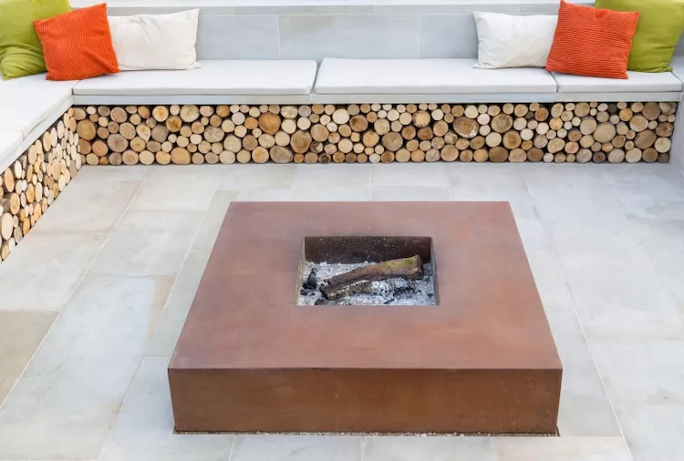 Stylish and minimalistic designed outdoor area with Corten steel fireplace and seating