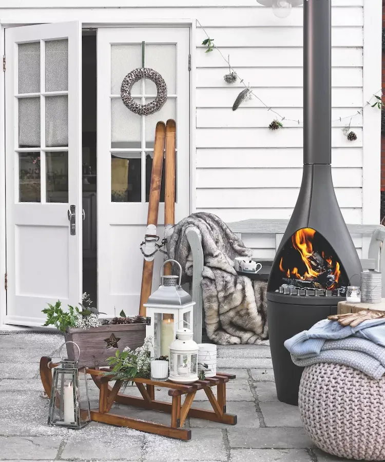 Neutral colors in Scandinavian style for a discreetly designed outdoor terrace with a modern fireplace